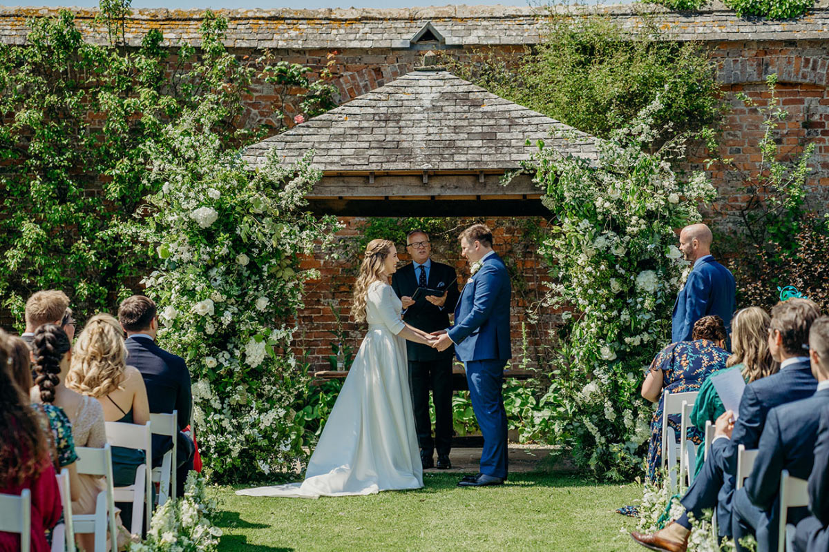 Wedding website hero design with the couple's names, event countdown, and RSVP button over a ceremony photo